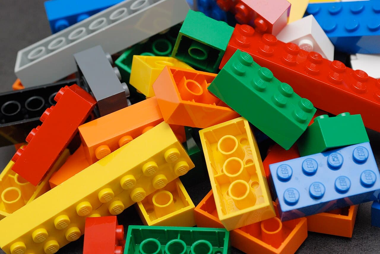 Multicolored interlocking plastic building blocks, a visual metaphor for assembling a commerce stack from swappable composable pieces.
