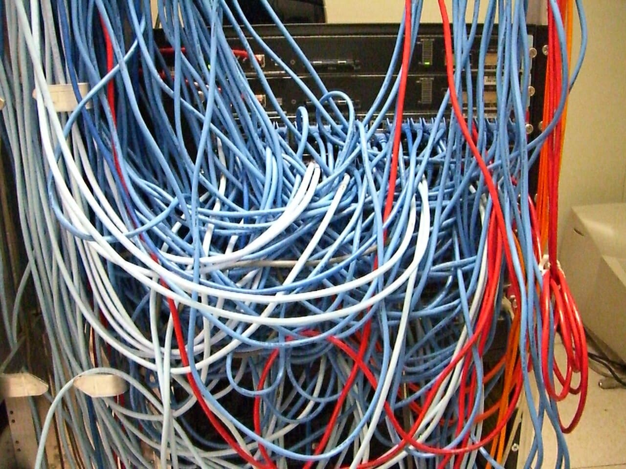 A server rack with a spaghetti-like mass of tangled network cables